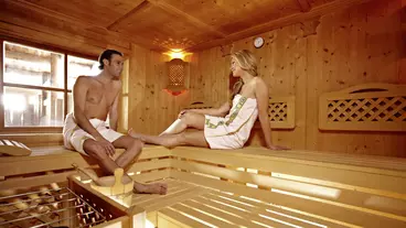 Ein Paar sitzt in einer Holzsauna 